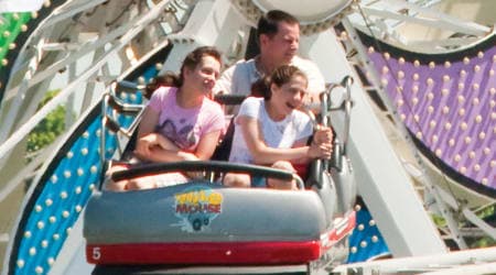 Family Riding Wild Mouse Coaster with the Ferris Wheel in background