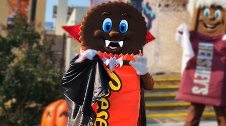 Life sized Reese's Peanut Butter Cup character smiling for picture with children